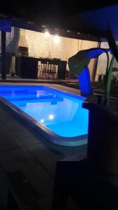 a swimming pool with a blue pool at Residencial mineiro in São Lourenço