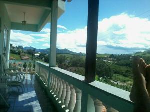 a person standing on a balcony looking out at the mountains at Residencial mineiro in São Lourenço