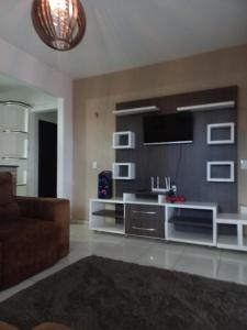 Una sala de estar con un sofá y un televisor. en Casa praia, en Barra Velha