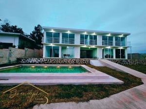 El AlcanforSerendipia espacio campestre的一栋前面有游泳池的房子