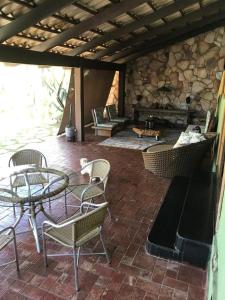 eine Terrasse mit einem Tisch, Stühlen und einem Kamin in der Unterkunft Casa linda in Goiânia