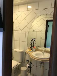 ein Badezimmer mit Waschbecken, Toilette und Spiegel in der Unterkunft Casa linda in Goiânia