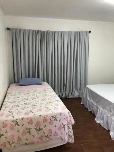 ein Schlafzimmer mit einem Bett mit geblümter Bettdecke in der Unterkunft Casa linda in Goiânia