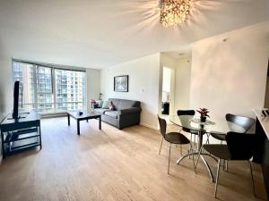 ein Wohnzimmer mit Sofa und Tisch in der Unterkunft Fabulous and convenient 2B2B close to Richmond center in Richmond