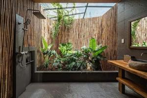 a bathroom with a shower with plants in it at Blue coconut villa in Kon Rung (1)