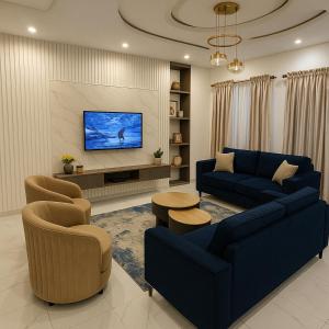 a living room with a blue couch and chairs and a tv at Fully Furnished Luxurious 4 Bedroom Apartment in Lekki