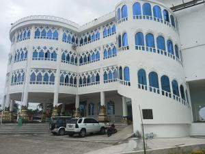 a building with cars parked in front of it at Hotel Palace in La Concordia