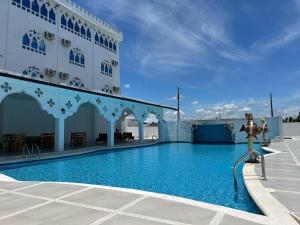 a woman standing on a rail next to a swimming pool at Hotel Palace in La Concordia
