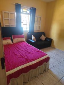 アハイアウ・ド・カボにあるMeu aconchegoのベッドとソファと窓のある寝室