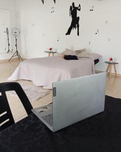 カボ・フリオにあるSuite Renascer Cabo Frioのベッドの横の床に置かれたノートパソコン