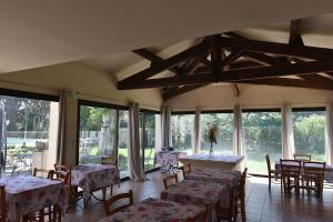 a dining room with tables and chairs and windows at Hôtel PRATO PLAGE in Pernes-les-Fontaines
