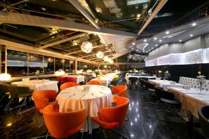 a restaurant with white tables and orange chairs at Cartoon Hotel in Istanbul