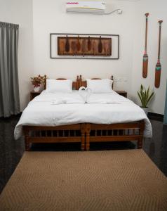 a bedroom with a large bed with white sheets at Paddle Cult Surf & Yoga in Varkala +106 photos