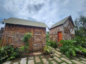 an old wooden cabin with a building next to it at Nhà Bên Hồ 2- The Peace's House in Ấp Thánh Hương