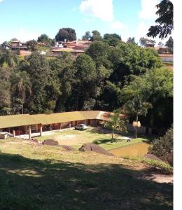 ein Gebäude mit einer Brücke in einem Park mit Bäumen in der Unterkunft Chácara Cachoeira in Socorro + 10 Fotos