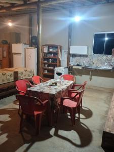 einen Tisch mit roten Stühlen in einem Zimmer in der Unterkunft Chácara Cachoeira in Socorro