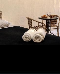 a bed with towels on it with a table at Villa Velha Flats in Itamaracá +38 photos