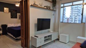 a living room with a flat screen tv on a wall at Apto a 5min da praia da Pompeia in Santos