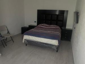 ZaragozaApartamento的带床和椅子的卧室