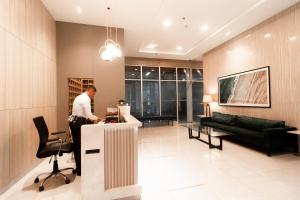 Un uomo in piedi al bancone in una stanza di MJ Modern Minimalist Studio Unit a Cagayan de Oro