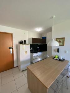 a kitchen with a white refrigerator and a counter top at Iloa Flat Resort Apt 207 bloco H in Barra de São Miguel