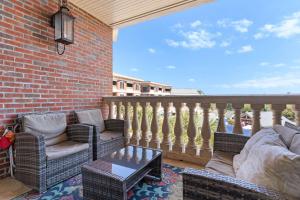 a patio with two chairs and a table on a balcony at The Village Blue Haven Condo - Private Beach Access Pool & Hot Tub in Rosemary Beach