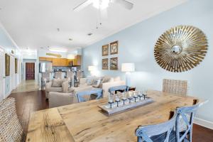 a dining room and living room with a large wooden table at The Village Blue Haven Condo - Private Beach Access Pool & Hot Tub in Rosemary Beach