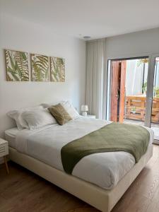 a white bedroom with a large bed and a balcony at Moodhu Villa - Cozy Apart w/ Amazing Terrace in Leiria