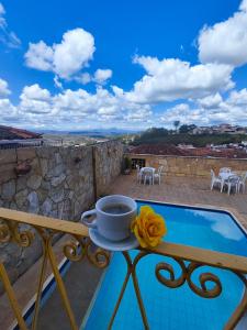 a cup of coffee on a table on a balcony at Hotel Montanhas de Minas in Diamantina