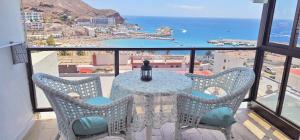 ein Tisch und Stühle mit Blick auf das Meer in der Unterkunft Guayarmina 201 in Mogán