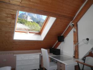 Zimmer im Dachgeschoss mit einem Schreibtisch und einem Fenster in der Unterkunft La grange in Menthon-Saint-Bernard