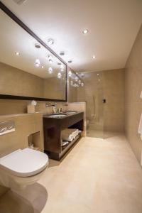 uma casa de banho com um WC, um lavatório e um espelho. em Mansio Suites The Headrow em Leeds