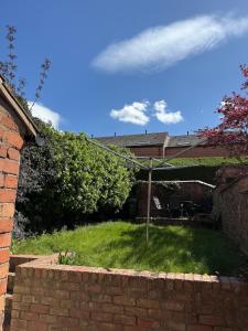 a yard with a brick wall and an umbrella at 5BR, Spacious with Free Parking in Coventry