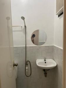 een badkamer met wastafel en douche met spiegel bij Happy Feet Siargao Homestay -General Luna in General Luna