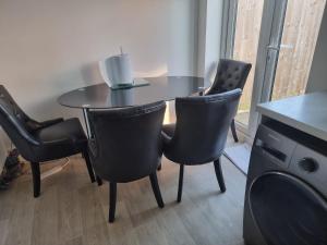 a dining room table with chairs and a table with a candle at Charming Modern Home in Cheltenham in Cheltenham +2 photos