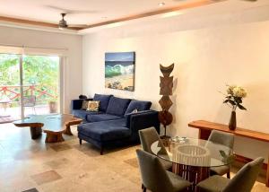 a living room with a blue couch and a glass table at #703 Pajaro de Fuego in Sayulita