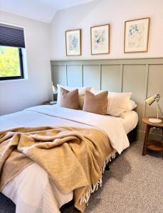 a bedroom with a large bed with a blanket on it at Central City Queenstown Retreat - 3 Bedroom Apartment in Queenstown