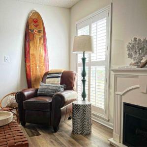 a living room with a chair and a lamp and a surfboard at Boutique Beachside condo with easy access to beach in Saint Augustine