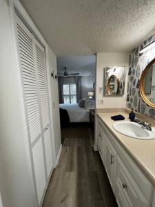 a bathroom with a sink and a bedroom with a bed at Boutique Beachside condo with easy access to beach in Saint Augustine