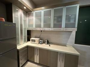 a kitchen with white cabinets and a microwave at JB home Mount Austin SemiD near Toppen IKEA Aeon fix to 14pax in Johor Bahru