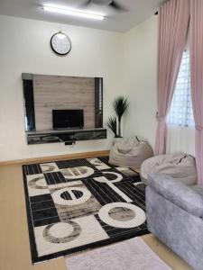 a living room with a couch and a rug at Homestay Ummi Baling in Baling