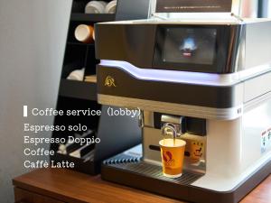 une machine à café expresso avec une tasse sur une table dans l'établissement Hotel Resol Trinity Kanazawa, à Kanazawa