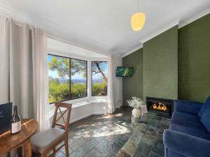 a living room with a blue couch and a fireplace at Bimbadeen Estate Villa 1 in Mount View