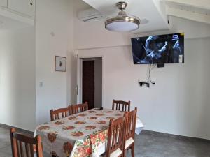 a dining room with a table and a tv on the wall at Casa en Venado Tuerto in Venado Tuerto