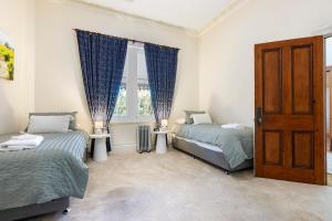 Washington Cottage في Angaston: غرفة نوم بها سريرين ونافذة