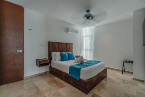 a bedroom with a large bed with blue pillows at Departamento con espectaculares vistas al mar in Telchac Puerto +69 photos