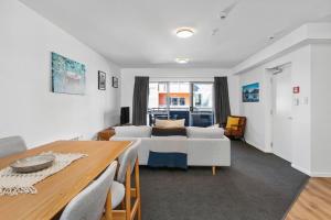 a living room with a bed and a table at Handy CBD Covered Free Parking Gym 2 Bdrm in Christchurch