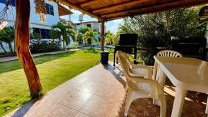 eine Terrasse mit einem Tisch, Stühlen und einem Grill in der Unterkunft Villa Cantomar - Punta Sal in La Bocana