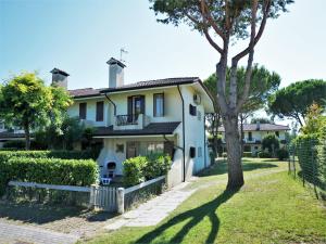 a house with a tree in front of it at Charming villa in Porto Santa Margherita with private garden in Porto Santa Margherita di Caorle