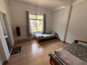 a room with two beds and a window at Alpine Homestay in Kohīma